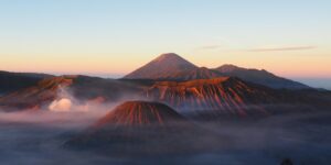 Mont Bromo lever de soleil : panorama mythique sur la mer de sable, cratère fumant et sommets volcaniques de Java Est.